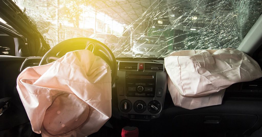 Blown airbags and wrecked windshield of a car that has been in an accident.