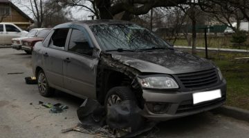 A damaged car after an accident, on the side of the road.